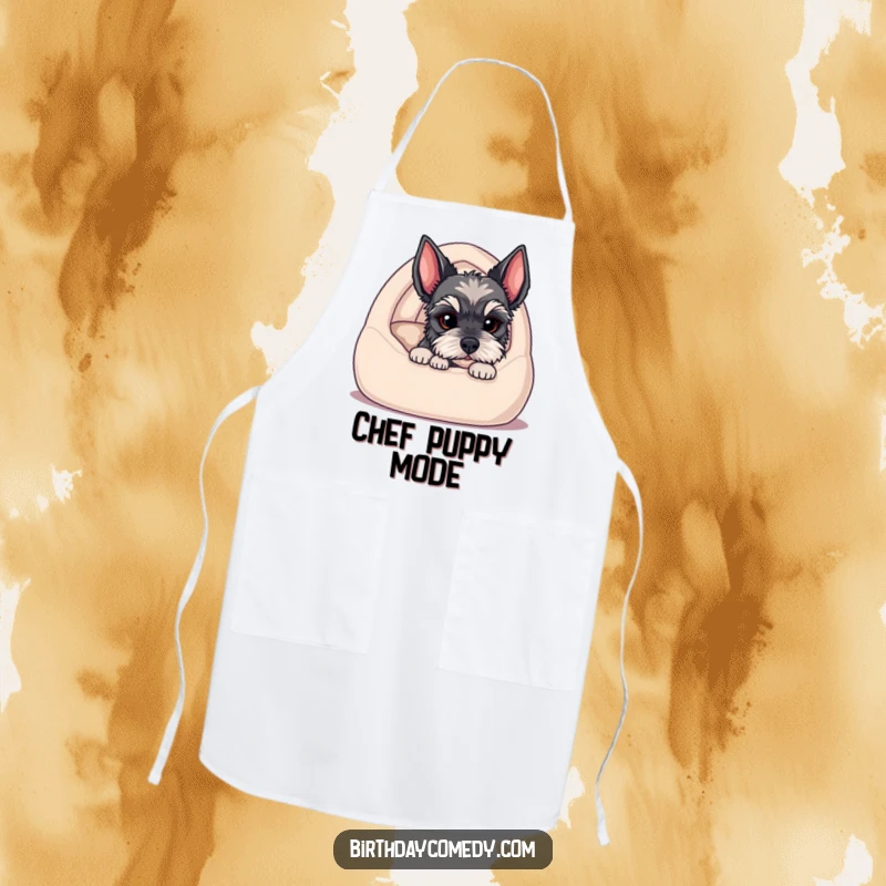 Funny apron featuring a schnauzer puppy peeking from a cozy bed, ready to add adorable charm to your cooking.