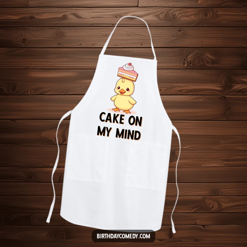 Funny Apron featuring a tiny duckling balancing a slice of cake on its head, ready for kitchen fun.