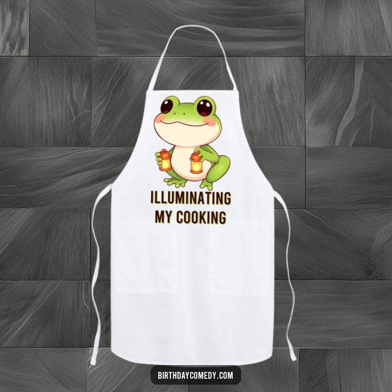 Funny apron showing a smiling frog holding a small, lit lantern, ready to assist in the kitchen with cheer.