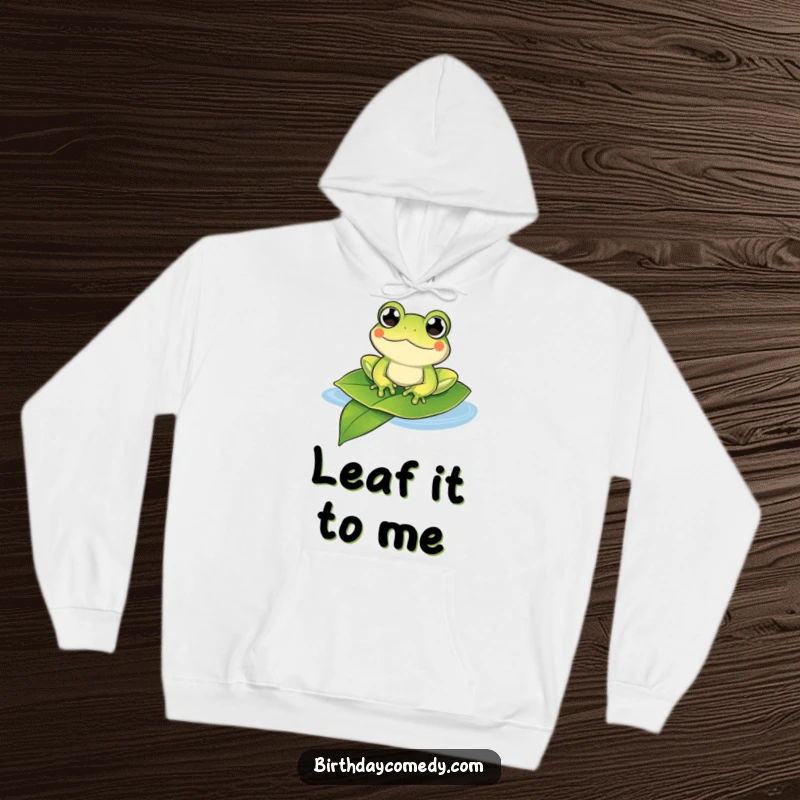 Funny frog hoodie showing a happy frog with bulging eyes floating on a leaf, offering cozy comfort and humor.
