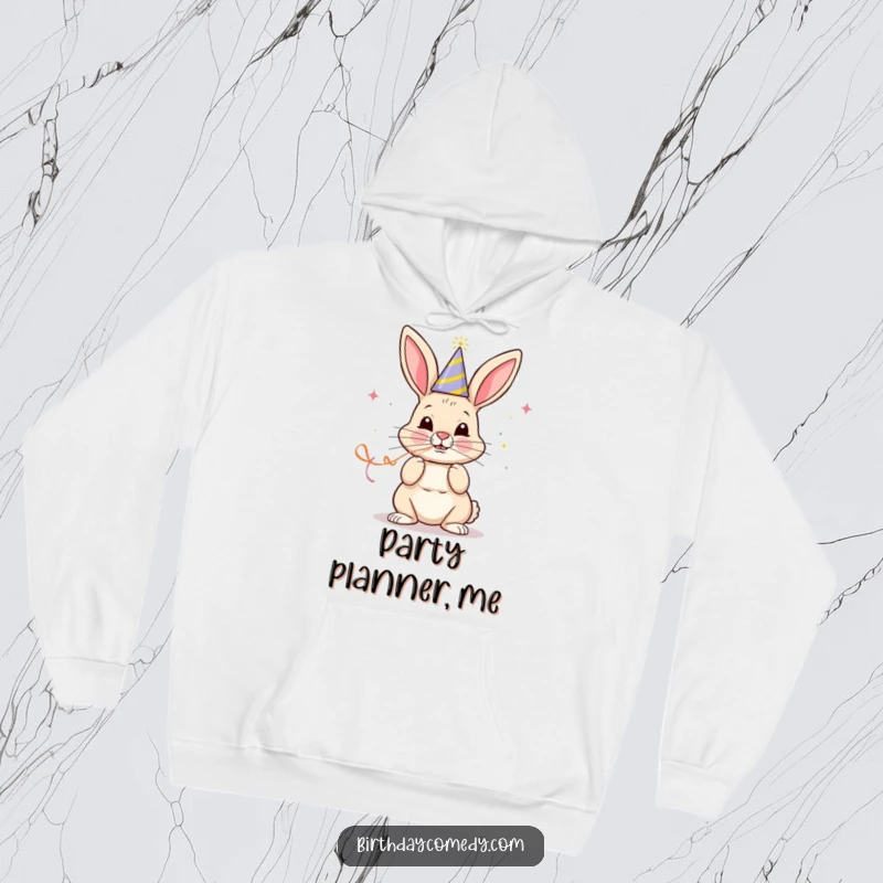 Funny hoodie with a cheerful bunny in a party hat blowing a streamer with great focus, perfect for festive warmth.