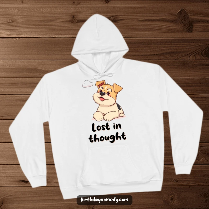 Funny terrier hoodie illustration of a content dog resting on paws, gazing thoughtfully at a distant cloud, promoting serenity.