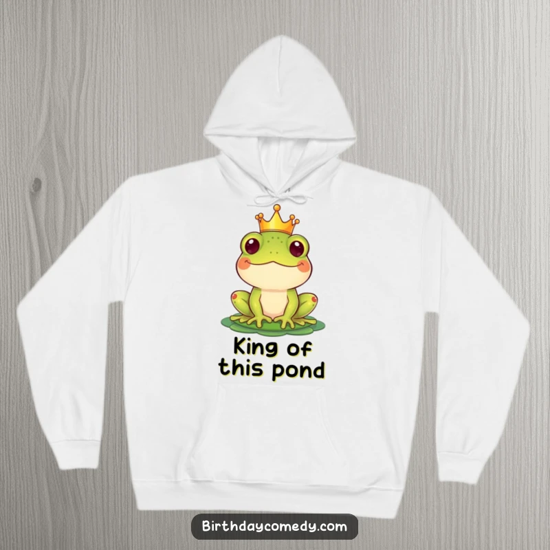 Funny Hoodie showcasing a majestic frog wearing a crown, balancing a lily pad as a hat, radiating pure joy.