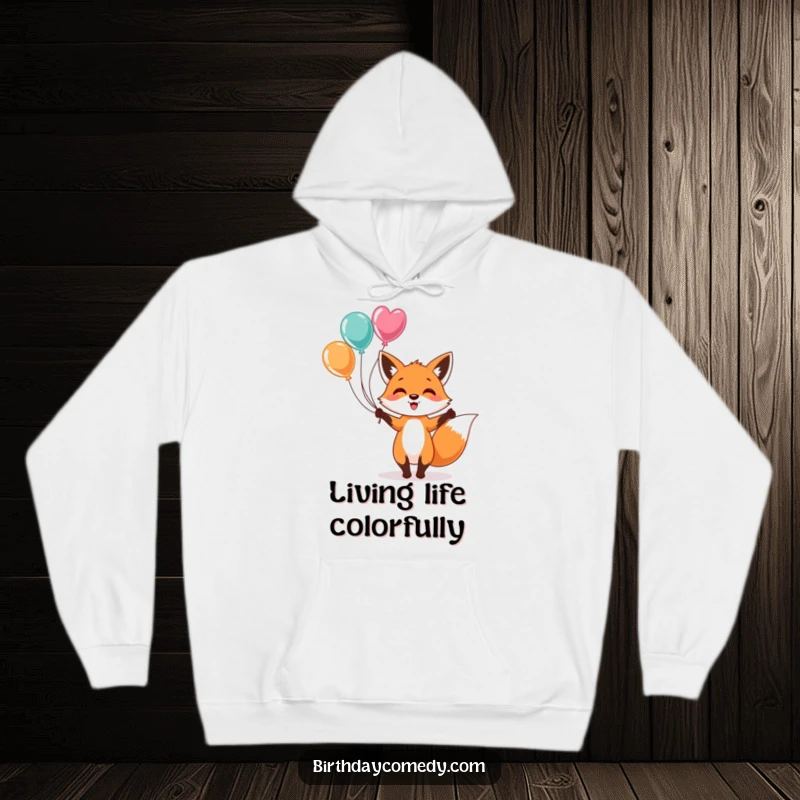 Funny Hoodie: A whimsical depiction of a happy fox skillfully juggling bright, colorful balloons, offering cozy comfort and a joyful outlook.