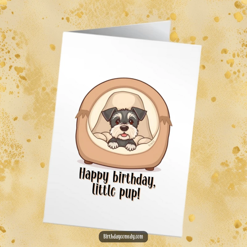 Funny Free Printable Birthday Card: Schnauzer puppy peeking from a cozy dog bed, cute and humorous birthday greeting, downloadable.