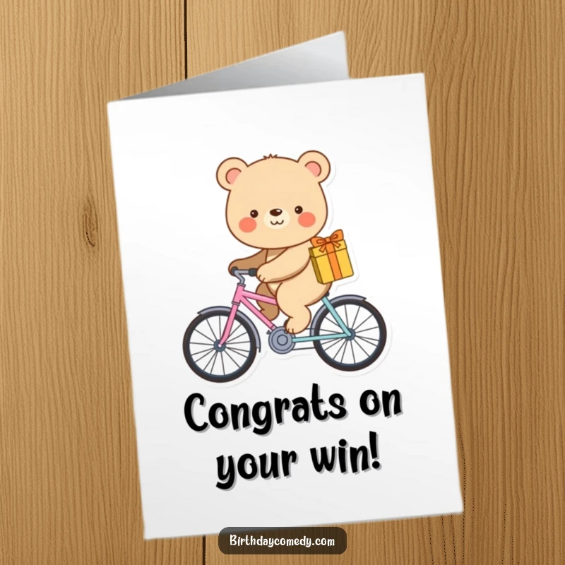 Funny free printable congratulations card showing a smiling bear on a small bicycle with a gift. Celebrating success humorously.