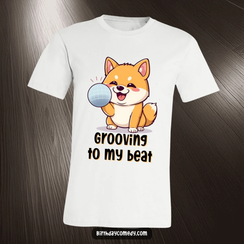 Funny Shiba Inu t-shirt showing a Shiba Inu gleefully batting at a disco ball with a determined grin, celebrating fun.