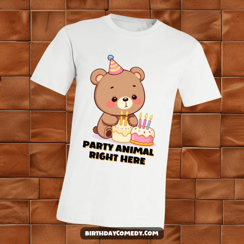 Funny birthday t-shirt with a cartoon bear wearing a party hat and blowing out candles on a small cake, celebrating joyfully.