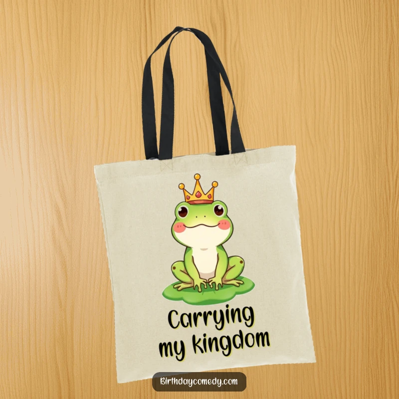 Funny tote bag illustrating a happy frog wearing a tiny crown and balancing a lily pad as a stylish hat, perfect for everyday use.