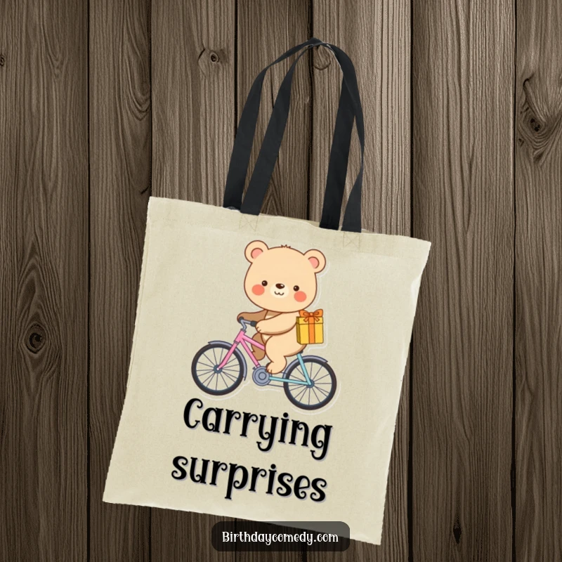 Funny tote bag showing a smiling bear riding a miniature bicycle with a wrapped gift.