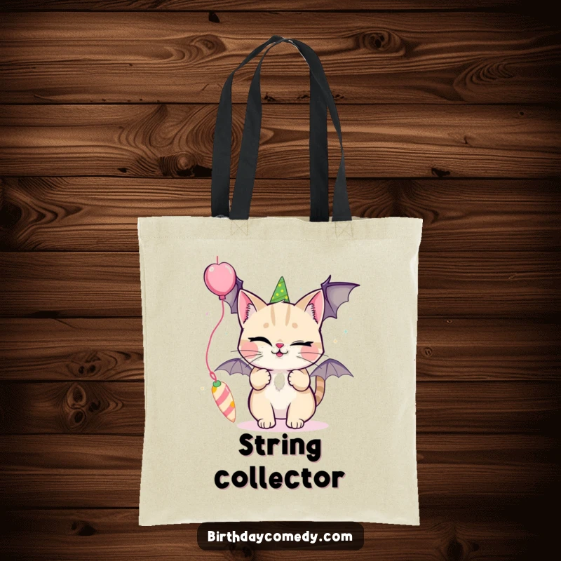 Funny tote bag depicting a winking cat playfully batting at a colorful, dangling party streamer.